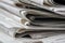 Macro shot of a stack of newspapers. The newspapers are folded