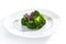 Macro Shot of Steamed Broccoli on White Restaurant Plate Isolated