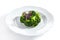 Macro Shot of Steamed Broccoli on White Restaurant Plate Isolated