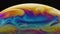 A macro shot of the surface of thin film of soap with rainbow colors creating a beautiful swirling effect. Semicircle of