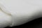 Macro shot texture pattern of folded white towel kitchen fabric isolated on black background