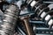 A Macro shot of the Threads of a small stainless steel bolt on a pile of washers, nuts and bolts.  Strong Contrast