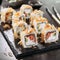 Macro shot of uramaki sushi rolls with cream cheese, salmon, tuna shavings or dried bonito, cucumber, nori. Portion of fresh katsu