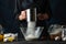 Macro shot view of chef sifts flour into the glass bowl for preparing the dough. Ingredients for cooking on the background. Dark