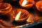 Macro shots of diyas being lit by hand or candle for the hindu religious festival of Diwali.