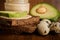 macro of sliced avocado on rye bread, quail eggs and tahini jar