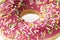 Macro sweet dessert of colorful pink donut. Texture donut closeup