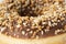 Macro sweet photo of chocolate donut. Texture donut with pieces of nuts closeup