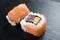 Macro of two sushi rolls japanese on a black plate