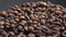 Macro view coffee seeds isolated on dark background. Vapor rising on grains.