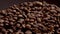 Macro view coffee seeds isolated on dark background. Vapor rising on grains.