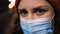 Macro view: Depressed young woman in medical mask looks at you