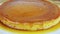 Macro view focus out from whole round homemade soft milk flan with caramel syrup