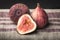 Macro view of fresh brown figs on striped linen towel.