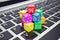 Macro view of heap colorful cubes with application icons and symbols on laptop keyboard depth field effect. 3d