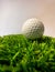 Macro of white golf ball on green artificial grass