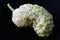 Macro of white mulberry fruit with details. Morus alba, white mulberry. On a black background