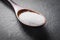 Macro Of A Wooden Spoon With White Grain Sugar On Slate Stone, Side View