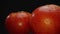 Macrography, tomatoes nestled within basket with black background. Comestible.