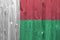 Madagascar flag depicted in bright paint colors on old wooden wall. Textured banner on rough background