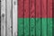 Madagascar flag depicted in bright paint colors on old wooden wall. Textured banner on rough background