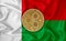 Madagascar flag, ripple gold coin on flag background. The concept of blockchain, bitcoin, currency decentralization in the country