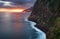 Madeira island - Dramatic sunrise over atlantic ocean with waterfall landscape from Miradouro do Veu da Noiva