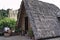 Madeira, Portugal: an isolated woman is doing housework in the garden of her traditional house with a thatched roof