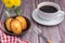 Madeleine homemade traditional French small cookies on black a dish with a cloth and a cup of coffee placed on a wooden background