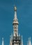 Madonnina atop Milan Cathedral at the height of 108.5 m in Milan, Italy. Golden statue of Madonna on spire on the blue sky