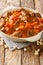 Mafe or Maafe is an authentic African peanut stew made in beef, spicy, creamy peanut butter and tomato sauce closeup in the pan.