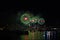 magenta green fireworks on beach and reflection color on water surface