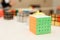 The magic cube lies on the table. Light background. Rubik`s Cube. A lot of magic cubes