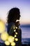 Magic light and feeling with woman and bulb yellow led in outdoor during sunset leisure activity - ocean background and meditation