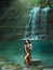 Magic tropical nature, dark-haired girl comes out of the azure transparent clear waterfall lake water, sea nymph in