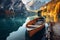 Magical autumn landscape with boats on the lake in Italian Alps. Boats reflecting in calm green waters of mountain lake on sunny