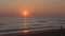 A magical golden sunset on the shores of Portugal. A woman is walking along the beach.