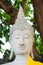 Magical head of sandstone buddha with yellow robe