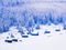 Magical mountain winter landscape, wooden houses and pine trees covered with snow