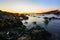 Magical and orange sunset on a rocky beach in Porto, Portugal, Europe. Long exposure shot