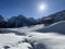 A magical play of sunlight and shadow during the alpine winter on the snowy slopes above the mountine resort of Arosa