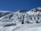 A magical play of sunlight and shadow during the alpine winter on the snowy slopes above the mountine resort of Arosa