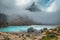 Magical Sorapis lake and misty mountains with colorful larches, Dolomites