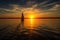 magical sunset on the water, with sailboat and sail in view