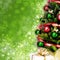 Magically decorated Christmas Tree with balls, ribbons and golden garlands on a blurred green shiny background