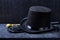 A magician`s set: tall hat, leather gloves and a knobbed cane on a black background