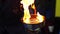 The magician sets fire to the flammable liquid in a metal dish.