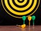 Magnetic dart arrows on granite surface and dart board background.