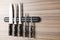 Magnetic holder with set of knives on wooden background