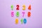 Magnetic multi-coloured numbers on purple background with copy space. Back to school